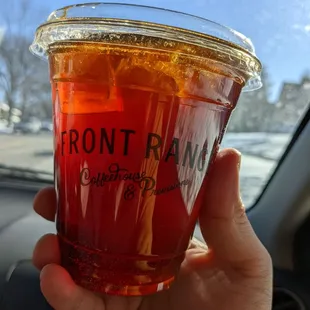 a hand holding a cup of iced tea