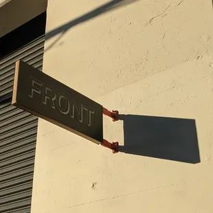 the shadow of a street sign on the side of a building