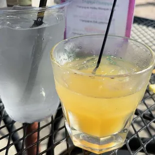 a glass of lemonade and a drink on a table