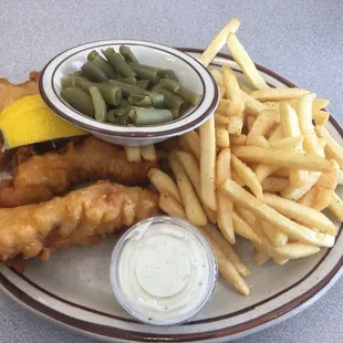 Fish, fries, green beans, and tarter sauce. With two slices of Lemmon.