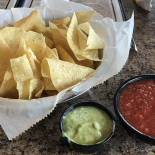 Complimentary chips with red and green salsa