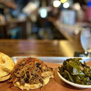 a pulled pork sandwich with a side of greens