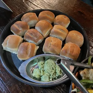 a plate of rolls and a bowl of vegetables