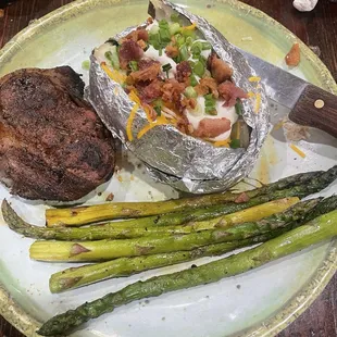 Filet mignon with a loaded baked potato and seasoned asparagus. Yum