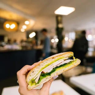 a person holding a sandwich
