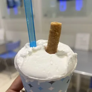 a hand holding a cup of ice cream