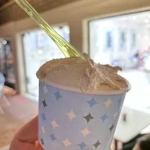 a hand holding a cup of ice cream