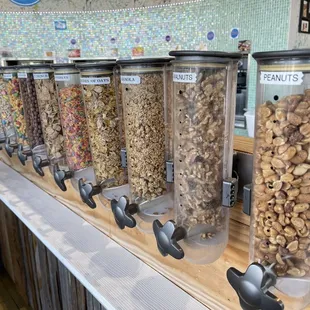 a row of cereal dispensers on a counter