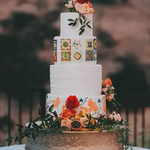 a three tiered cake with flowers on top