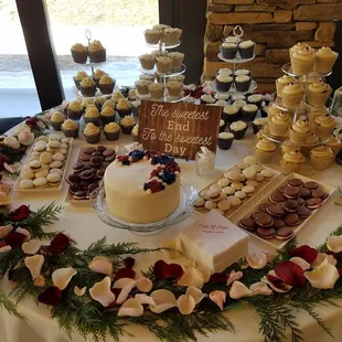 A custom wedding cutting cake with an arrangement of specialty cupcakes.
