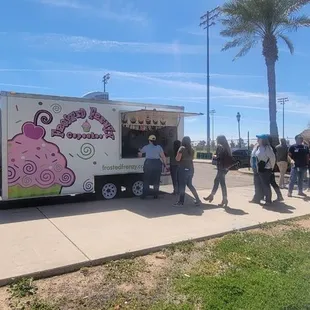 a group of people standing outside of a food truck