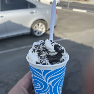 a person holding a cup of ice cream