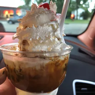 a hand holding a cup of ice cream