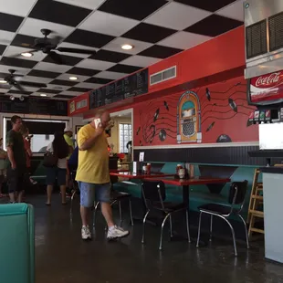 a man in a yellow shirt standing in a diner
