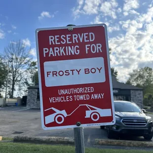 a red and white parking sign