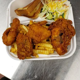 fried chicken and french fries in a styrofoam container