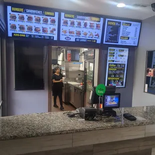 a woman standing at a counter in a fast food restaurant
