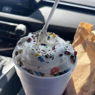 a hand holding a cup of ice cream