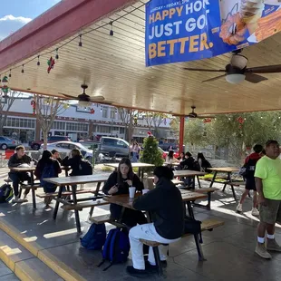 people sitting at tables under a canopy