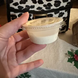 a hand holding a cup of yogurt