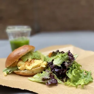 a sandwich and salad on a paper plate