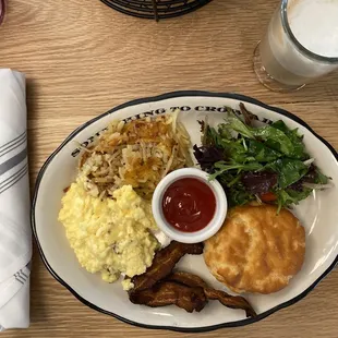 Classic breakfast with eggs, hash, crispy bacon and a biscuit.