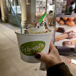 a person holding a cup of ice cream
