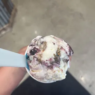 a hand holding a scoop of ice cream