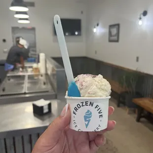 a hand holding a cup of ice cream