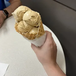 a person holding a cone of ice cream