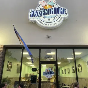 people sitting at tables outside a restaurant