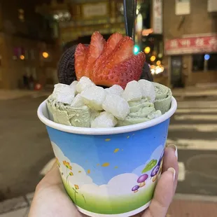 a hand holding a cup of icecream