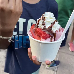 a child holding a cup of icecream