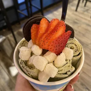 a hand holding a bowl of icecream