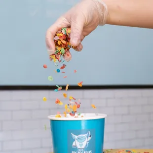 a person scooping out a bowl of sprinkles