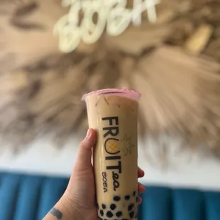 a hand holding a cup of boba