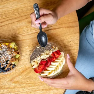 a woman eating a bowl of fruit