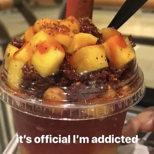 a cup of fruit juice with a spoon sticking out of it