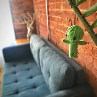 a green stuffed animal hanging from a tree