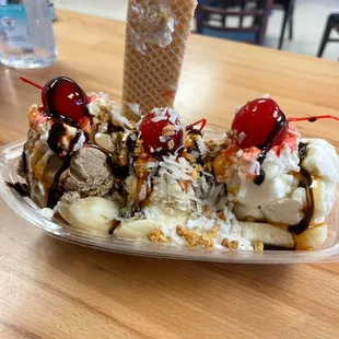 a banana split with ice cream, whip cream, and cherries