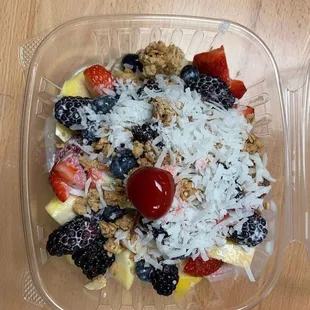a plastic container of fruit and granola