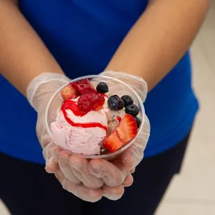 a person holding a bowl of fruit