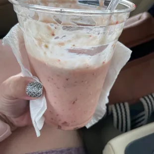 a woman holding a drink in a car