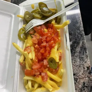Fries with nacho cheese, jalapeños, and tomatoes