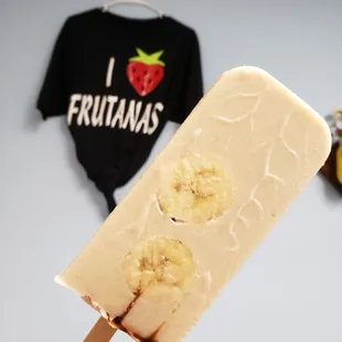 a hand holding a popsicle with bananas on it