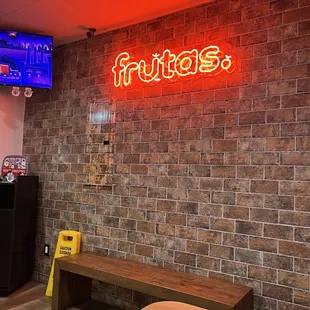 a brick wall with a neon sign