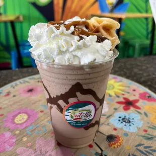 a chocolate milkshake topped with whipped cream