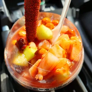 a fruit salad in a plastic cup