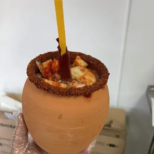 a hand holding a cup with a drink in it