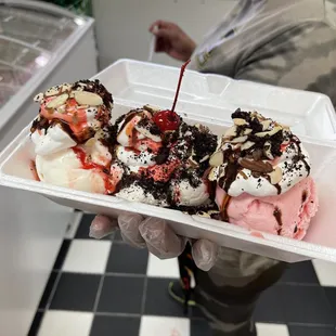 a man holding a tray of ice cream sundaes